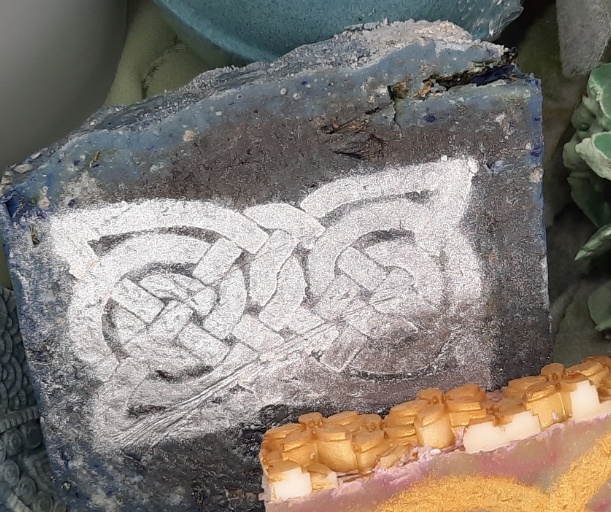 Decorative soap bars with intricate designs on a wooden surface