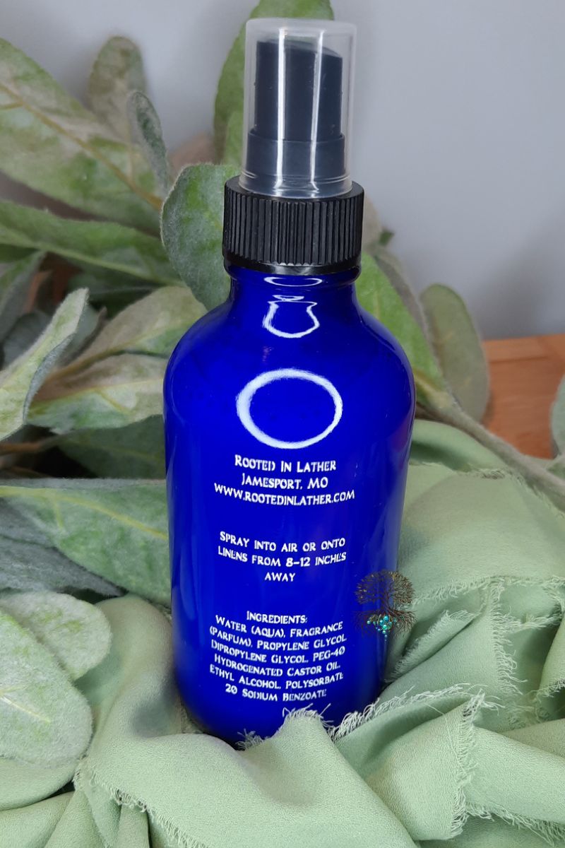 Blue spray bottle with black nozzle on a green fabric background