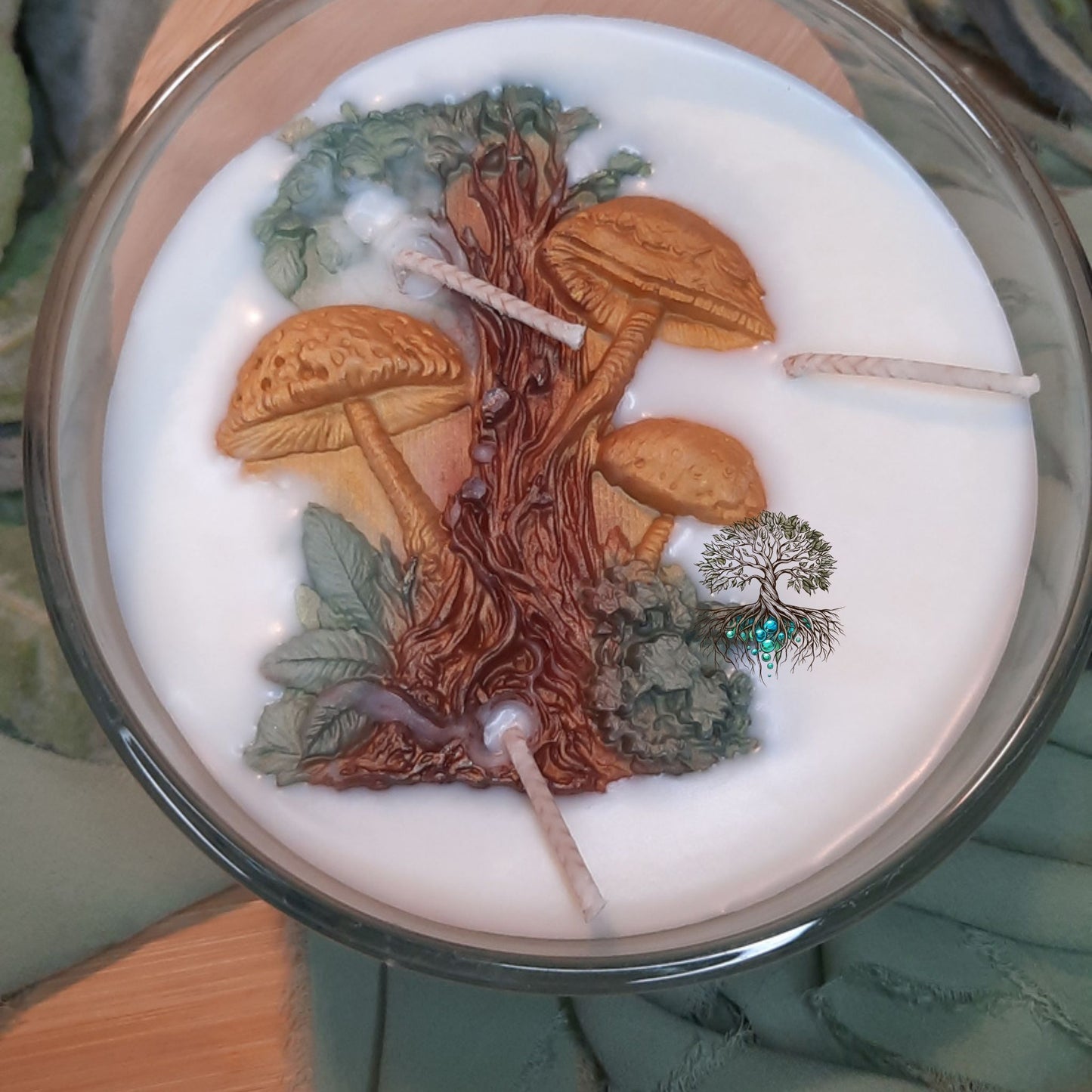 Candle with forest-themed design featuring mushrooms and trees.