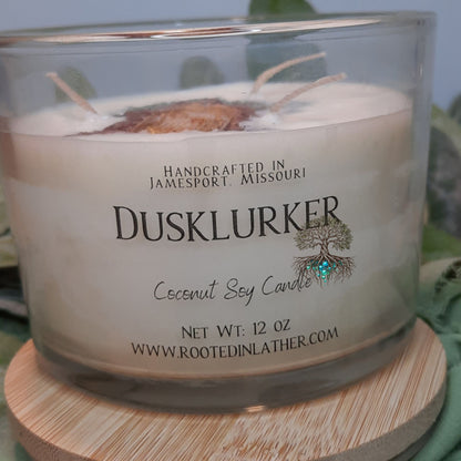 Coconut soy candle labeled 'DuskLurker' on a wooden coaster with a blurred background.