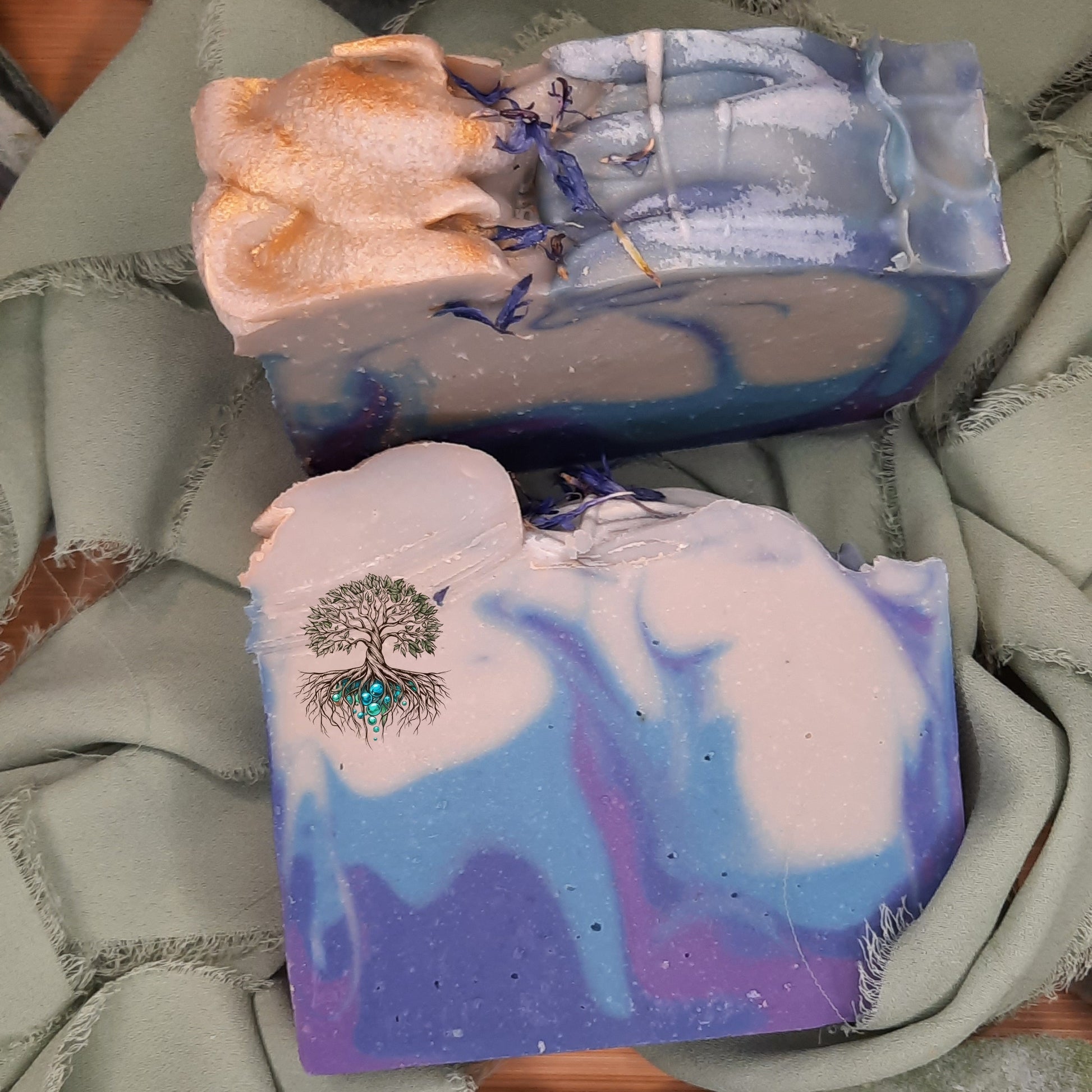 Three bars of soap with artistic designs on a textured surface