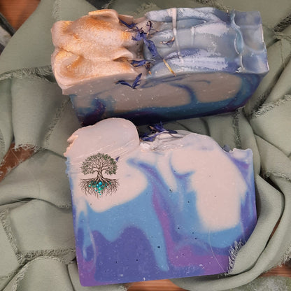 Three bars of soap with artistic designs on a textured surface