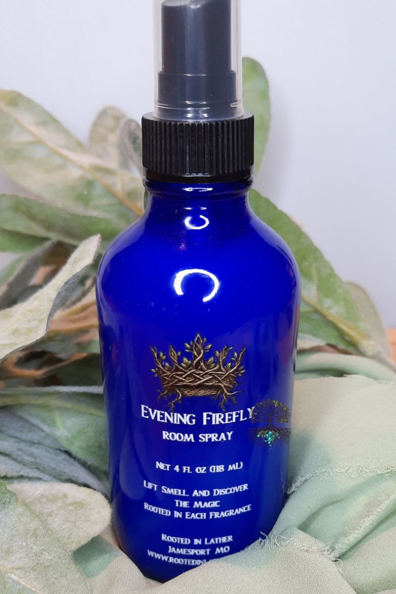 Blue bottle of Evening Firefly room spray on a green leafy background