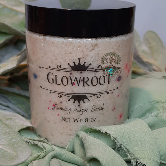 Jar of Glowroot foaming sugar scrub on a green fabric background