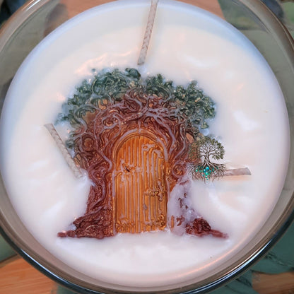 Candle with a decorative design of a door and trees on top