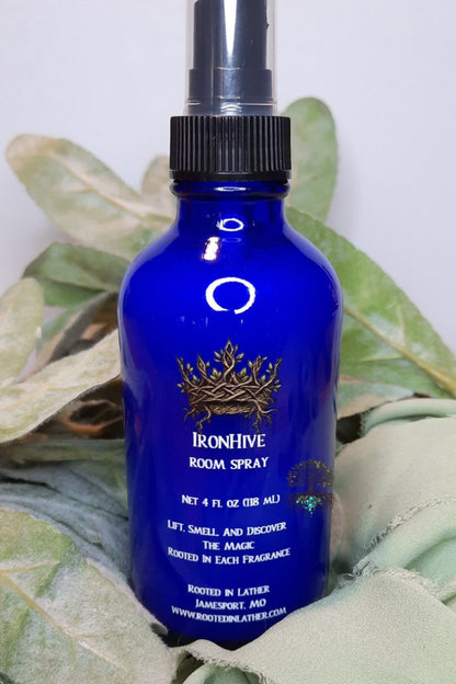 Blue room spray bottle with Ironhive branding on a leafy background