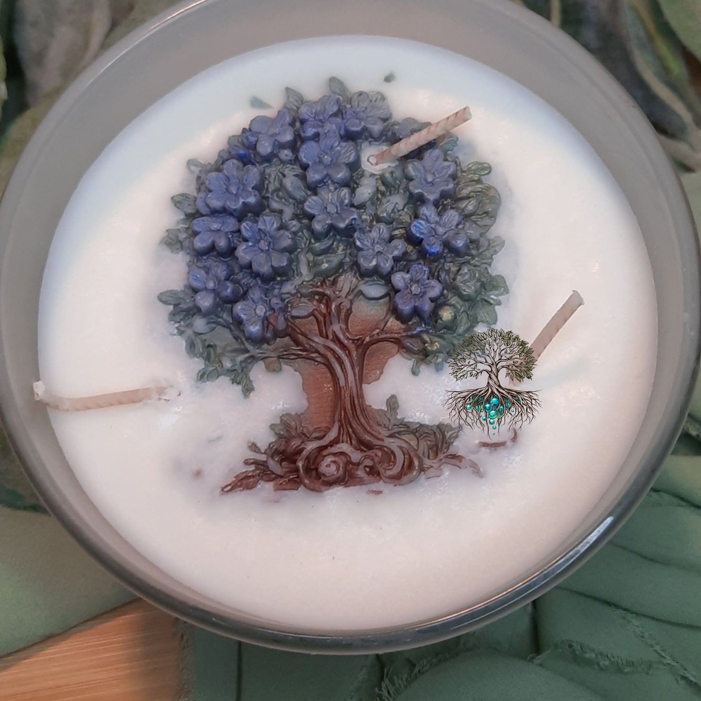 Candle with a tree and flower design on top