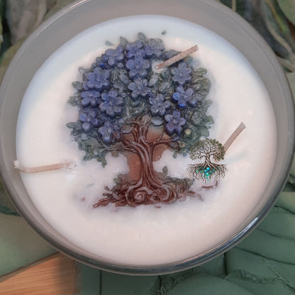 Candle with a tree and flower design on top