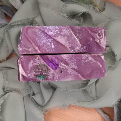 Purple soap bar with a tree design on a textured gray background