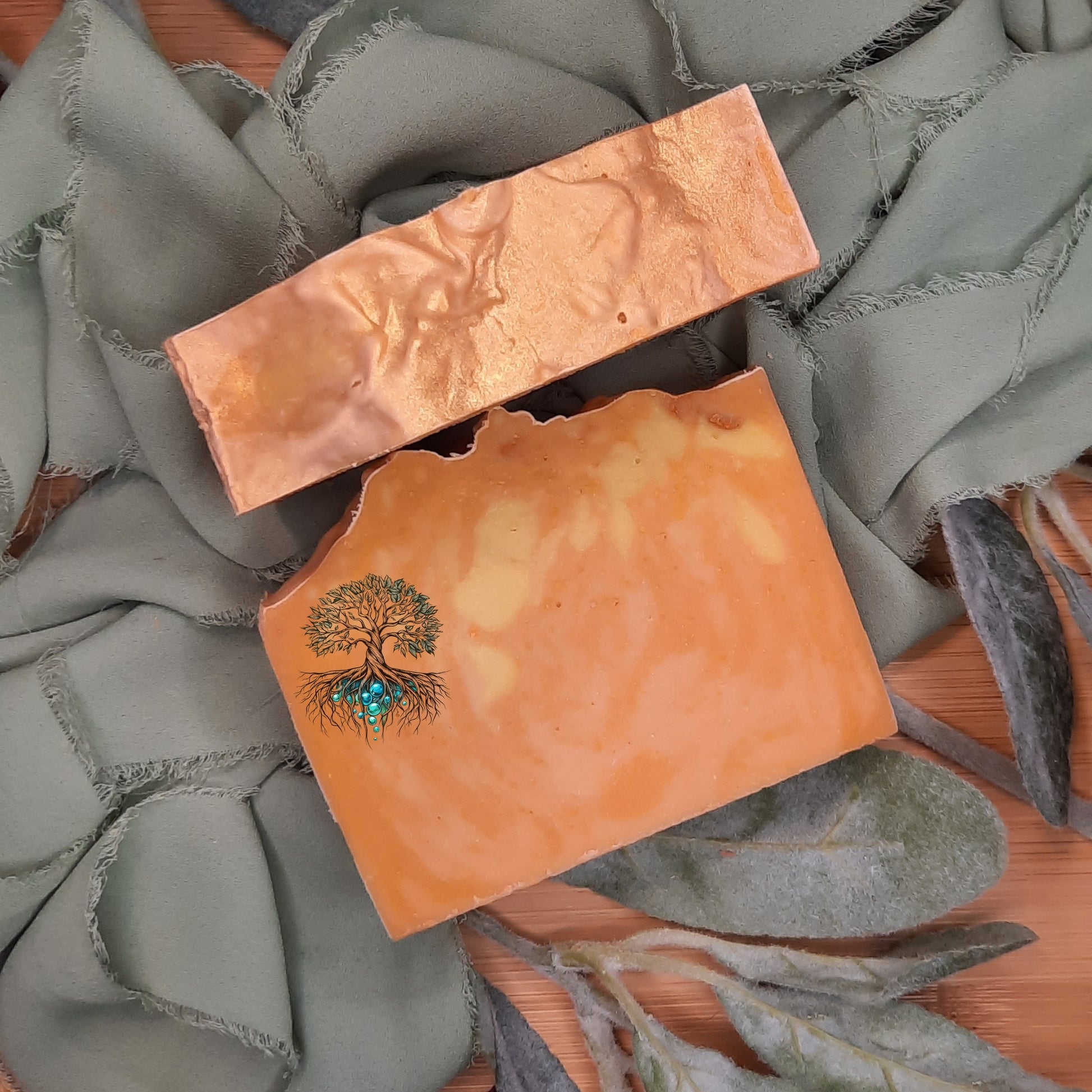 Two soap bars with tree designs on a textured surface