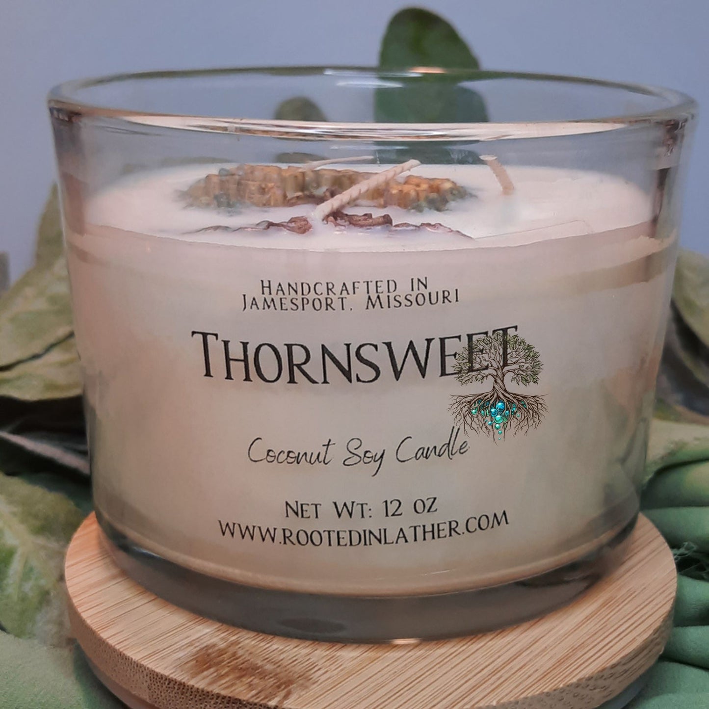 Thornsweet coconut soy candle on a wooden coaster with a blurred background