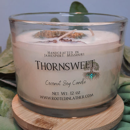 Thornsweet coconut soy candle on a wooden coaster with a blurred background