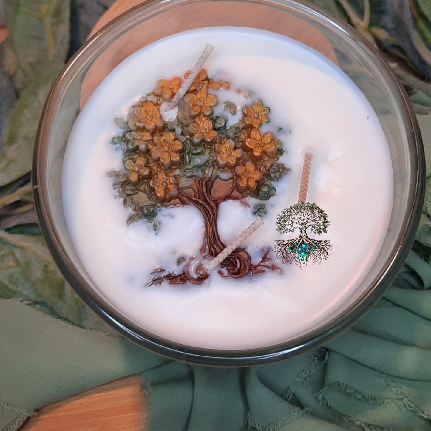 Candle with tree design in a glass container on a textured surface