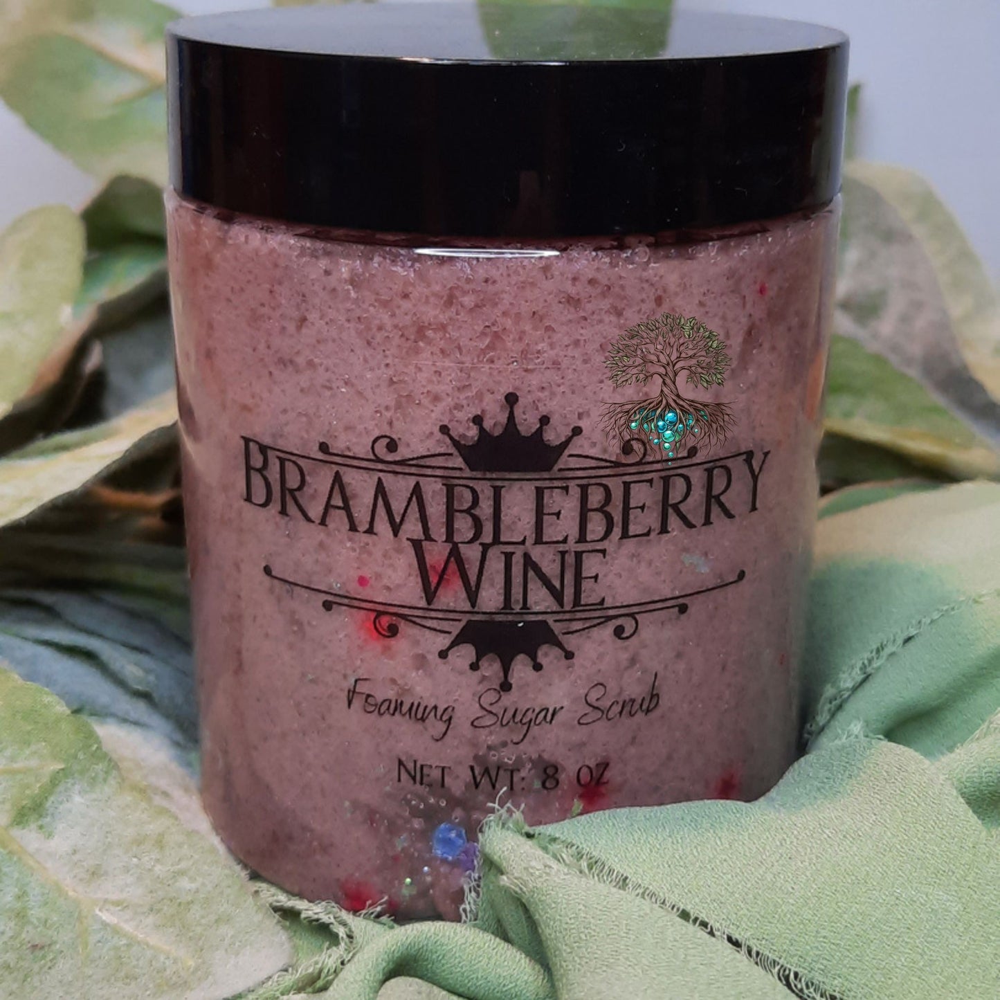 Jar of Brambleberry Wine body scrub on a green leafy background
